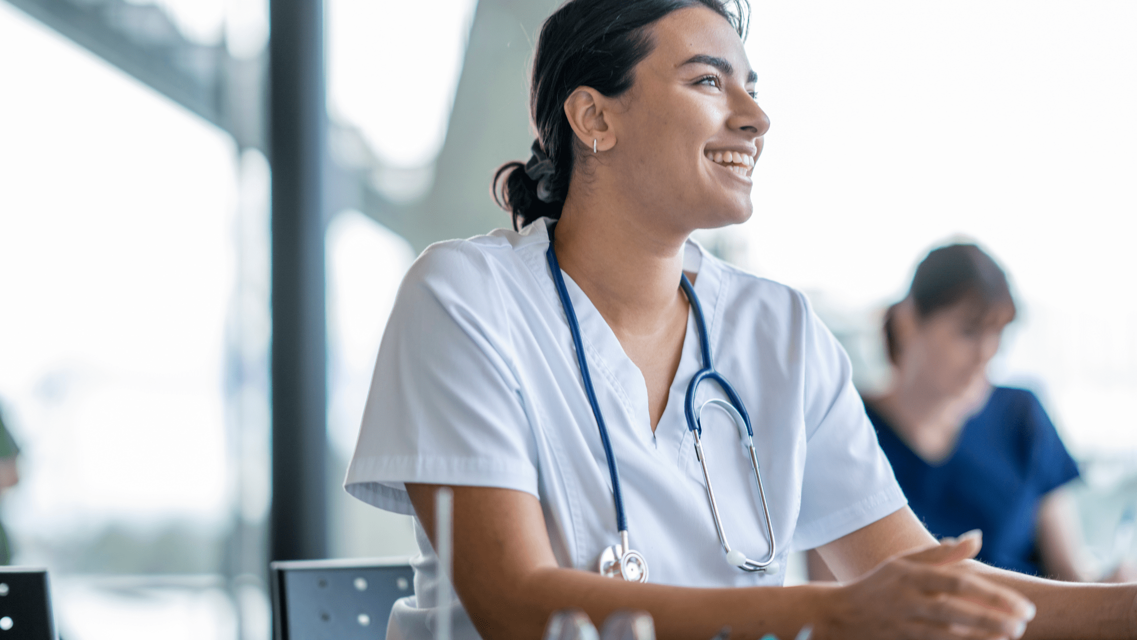 An excited medical school student in scrubs after having received her USMLE Step 1 score report.
